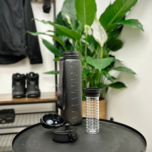 Die 720°Dgree uberBottle ist vollständig zerlegt. Neben der Flasche liegen Deckel, Fruchteinsatz und Sieb.