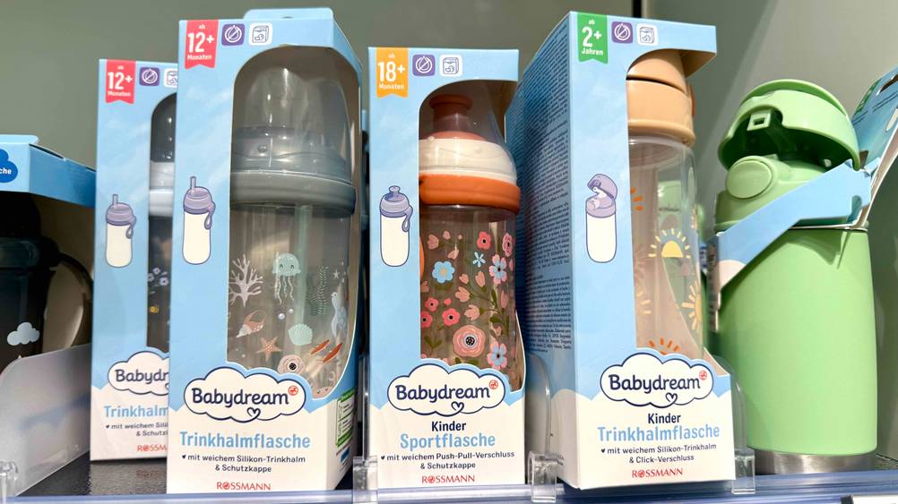 Trinkflasche ab 18 Monate im Test: Mehrere Flaschen stehen in einem Verkaufsregal neben anderen Produkten.