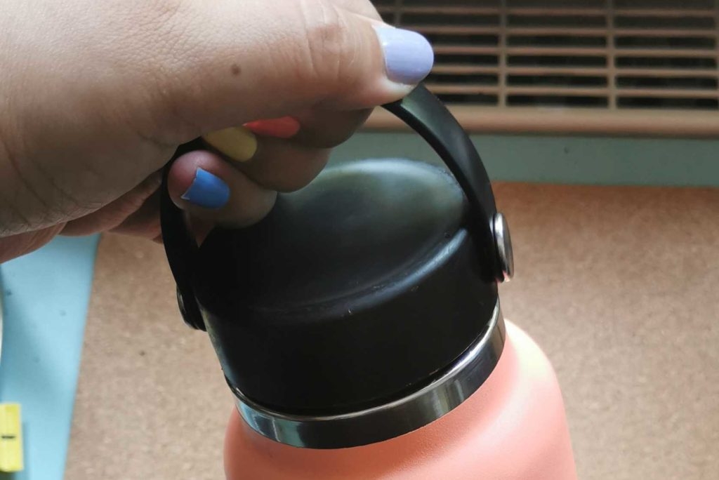 Eine Hand hält den Griff einer Edelstahl-Trinkflasche fest.