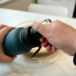 Eine Hand betätigt den Drehverschluss der Trinkflasche.