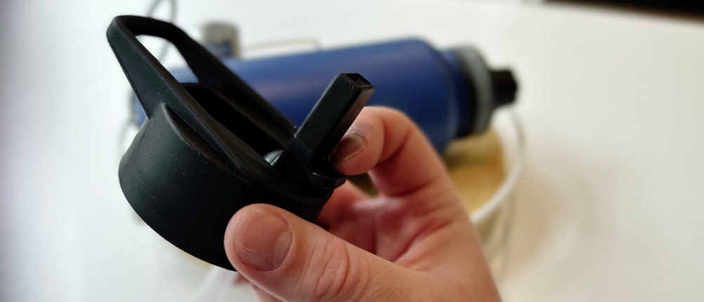 Eine Hand hält den Deckel der Trinkflasche.