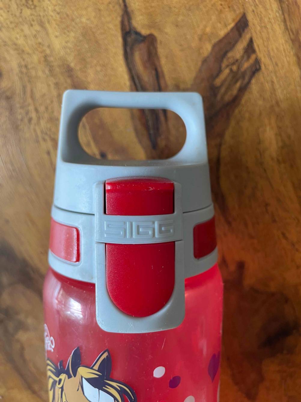 Nahaufnahme der Verschlusskappe einer Trinkflasche für Kinder im Test auf einer Holzfläche.