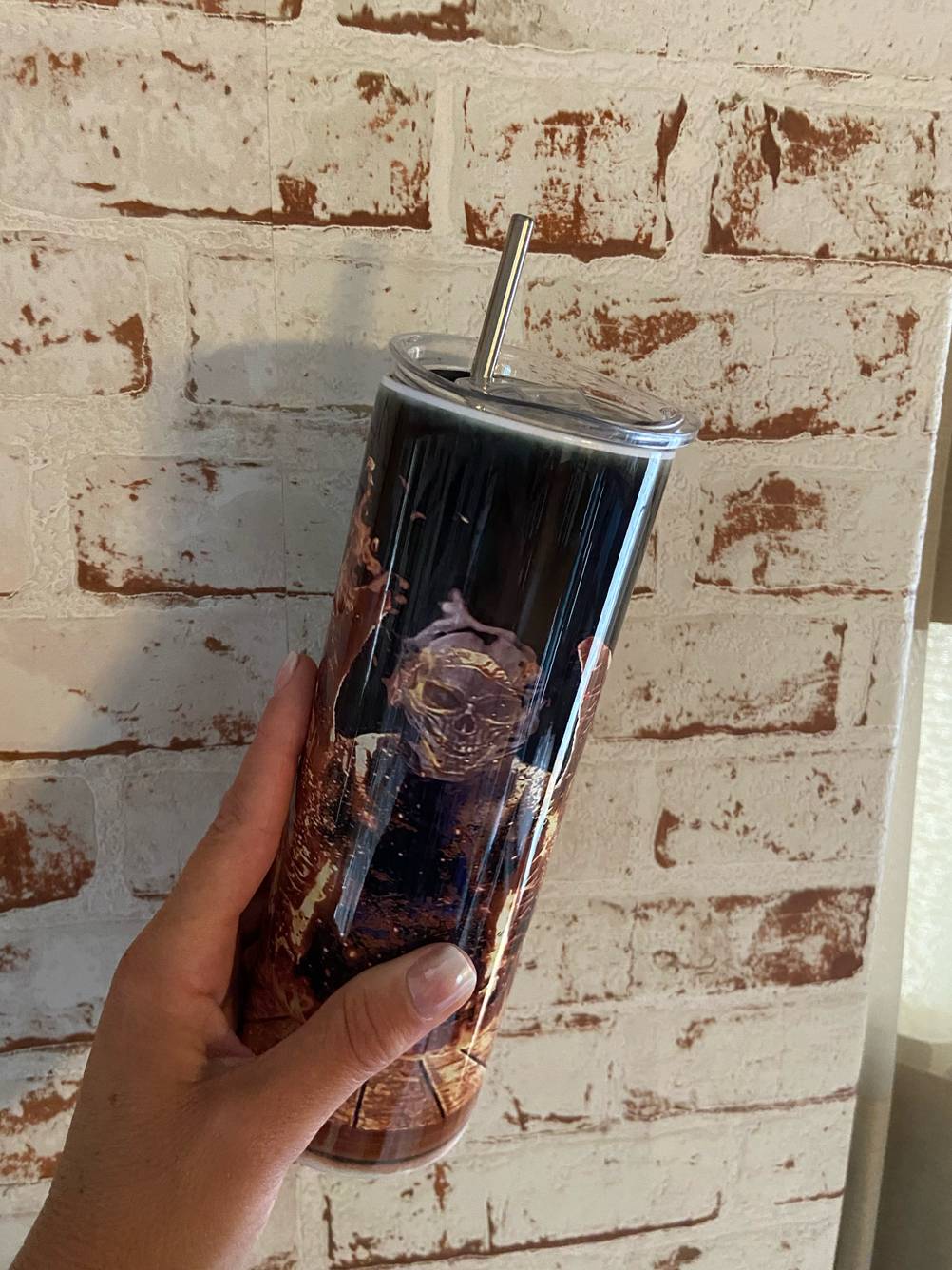 Eine Hand hält die getestete Trinkhalmflasche vor eine Wand.