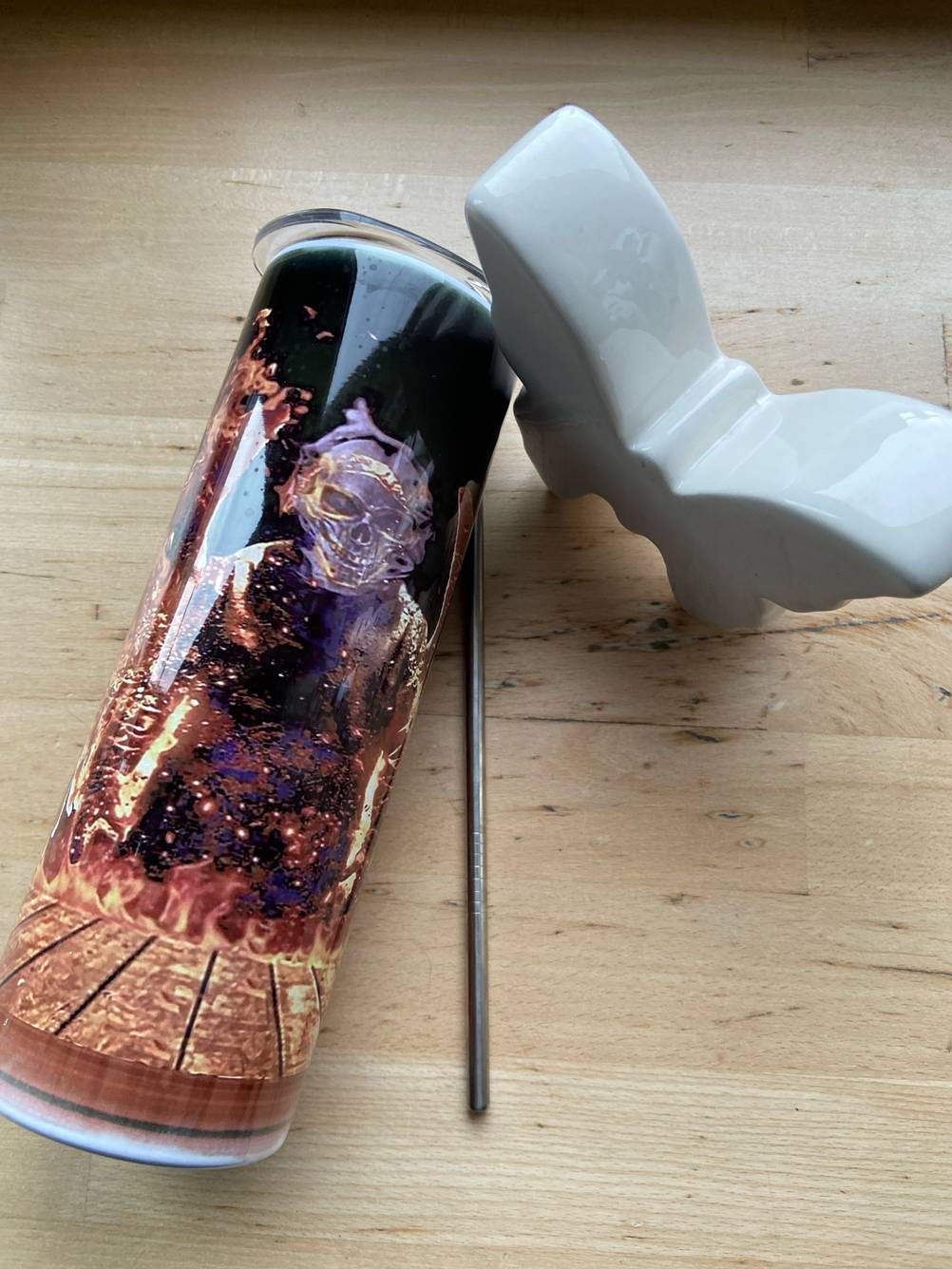 Die getestete Trinkhalmflasche liegt neben dem Trinkhalm auf einem Holztisch.