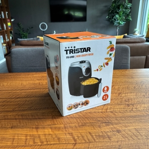 Der Karton der Tristar FR-6980 steht auf einem Holztisch.