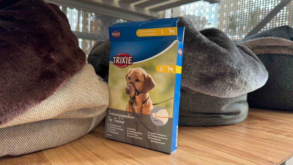 Die Verpackung eines getesteten Erziehungshalsbands steht zwischen zwei Kuschelkörben.