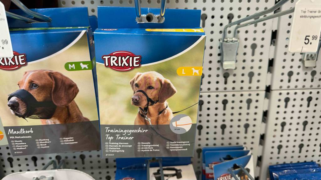 Ein verpacktes Erziehungshalsband hängt zum Testen neben anderen Tierprodukten in einem Hängeregal.