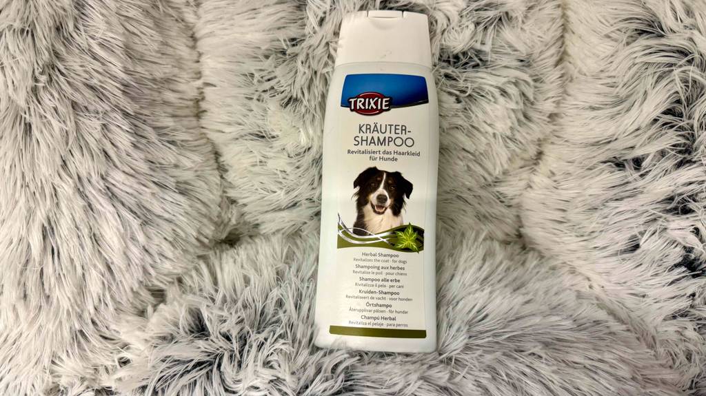 Eine Flasche Trixie-Hundeshampoo liegt zum testen auf einer flauschigen Unterlage.