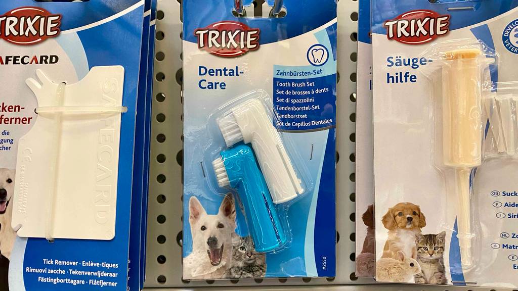 Katzenzahnbürste im Test: Eine Packung hängt zwischen anderen Produkten an einem Lochregal.