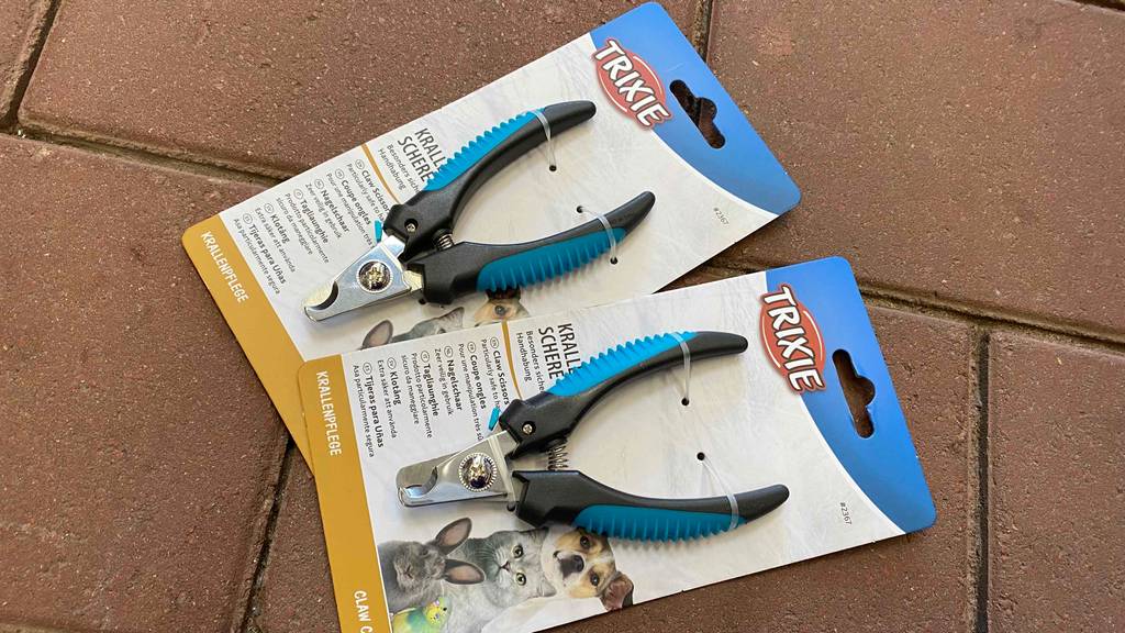 Krallenschere im Test: Zwei Krallenscheren in Verpackung liegen auf Steinuntergrund.