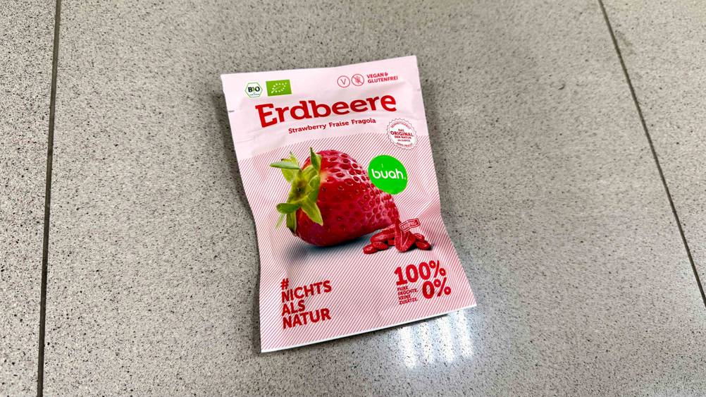 Auf einem Fließenboden liegt eine Packung der getesteten Trockenfrüchte.