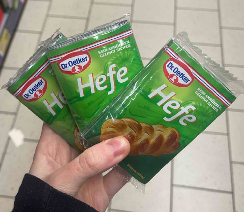 Im Test: Eine Hand hält drei Packungen Trockenhefe in Fächerform.
