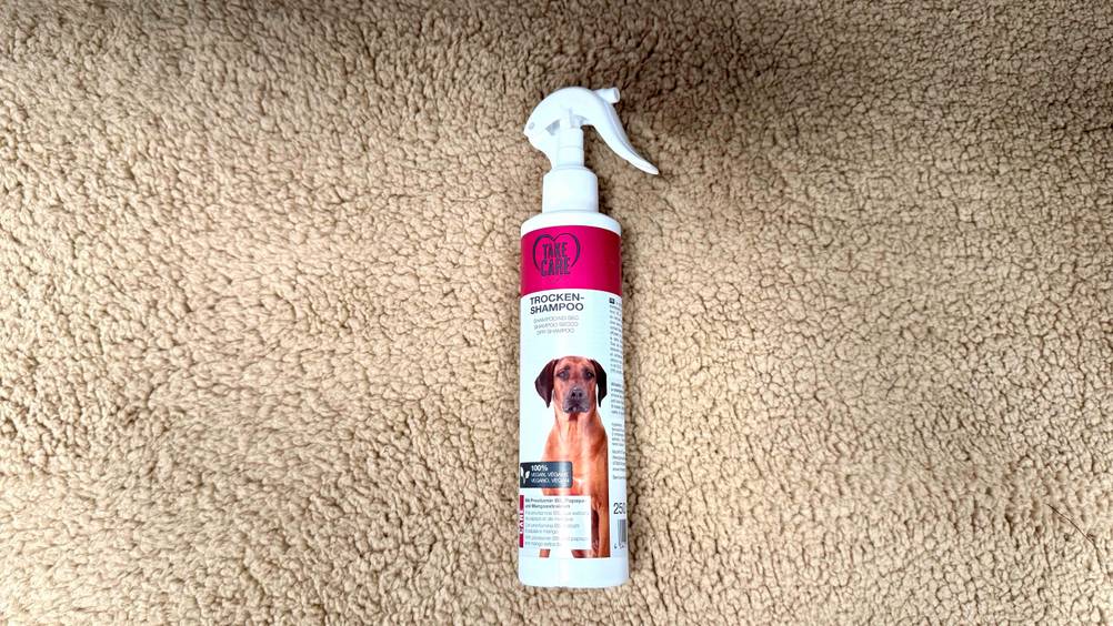 Trockenshampoo Hund im Test: Eine Flasche liegt auf einem beigen Untergrund.