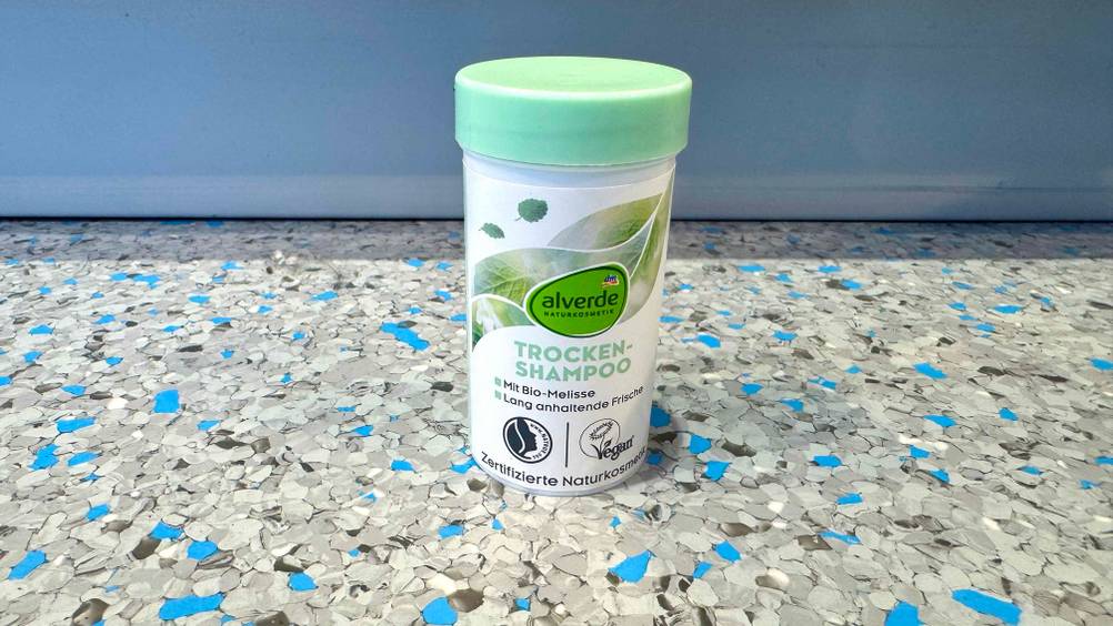 Trockenshampoo-Puder im Test: Eine Dose steht vor einem blauen Regal auf dem Boden.