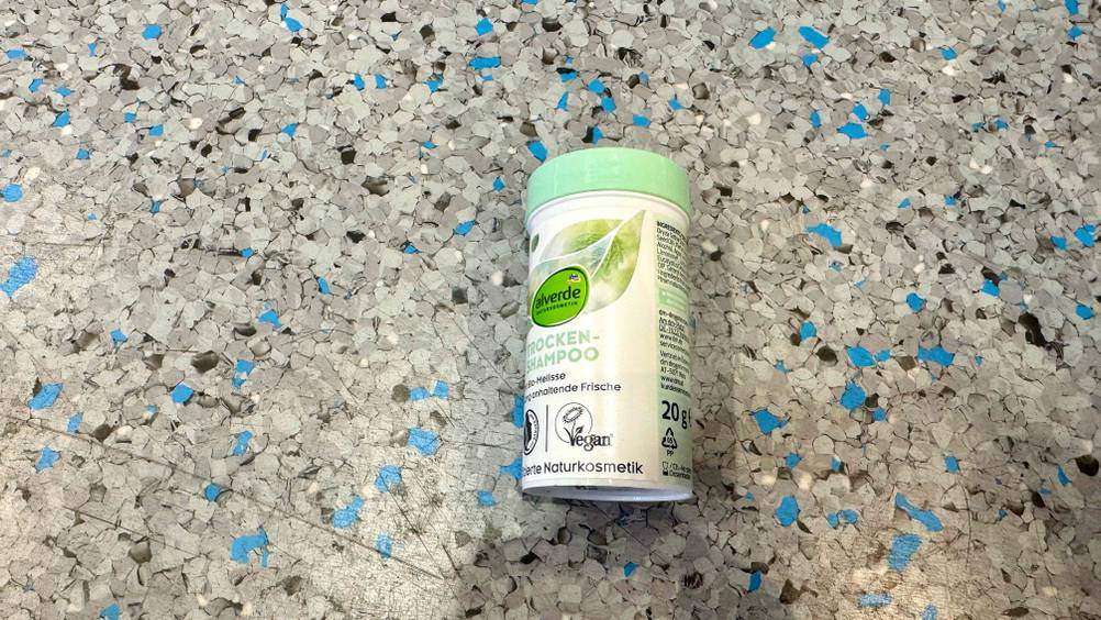 Eine Dose Trockenshampoo-Puder im Test von der Seite auf dem Boden liegend.
