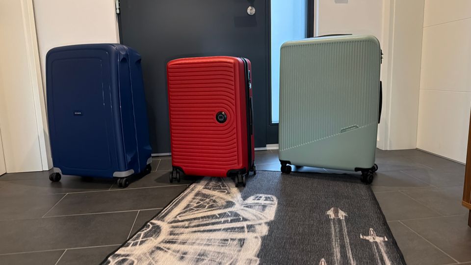 Drei Trolleys stehen nebeneinander auf einem Fliesenboden.