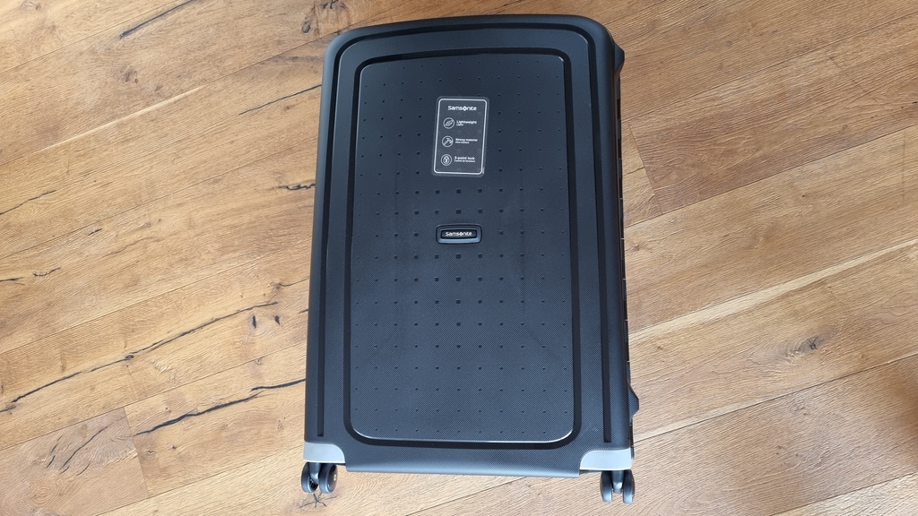 Samsonite-S-Spinner-Hartschalenkoffer liegt geschlossen auf dem Boden.