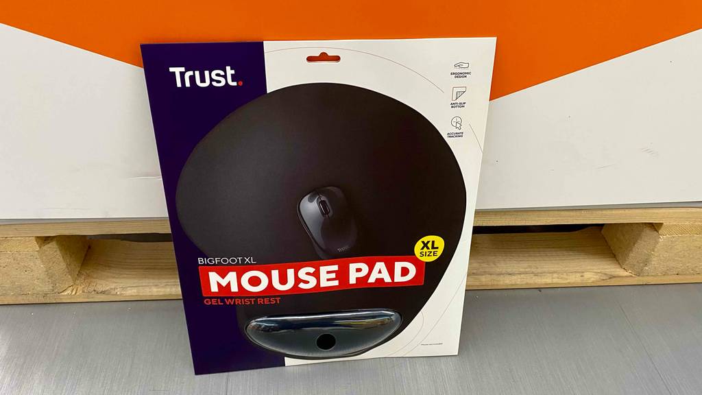Ein schwarzes XL Trust Mauspad mit Handauflage im Test befindet sich in seiner Originalverpackung vor einer Palette im Verkaufsbereich.