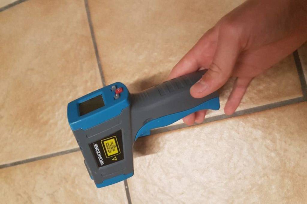 Blau-graues Workzone Infrarot-Thermometer im Test in einer Hand.