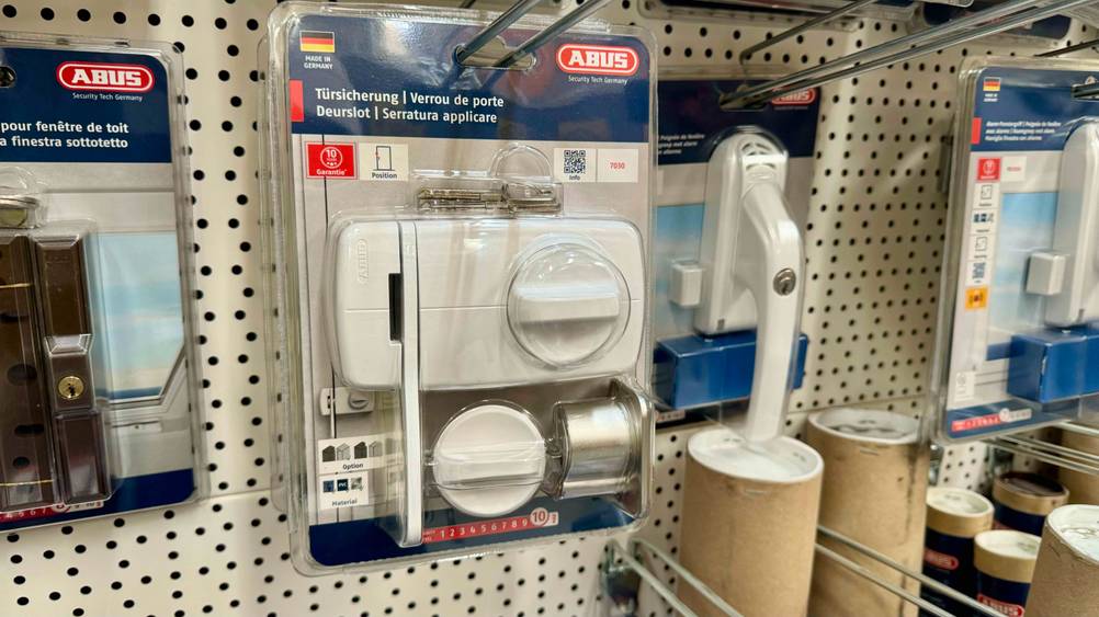 Tür-Zusatzschloss im Test: Ein originalverpacktes Produkt hängt neben anderen in einem Verkaufsregal.