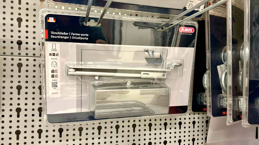 In einem Regal hängt ein transparent Verpackter Türschließer Haustür im Test.