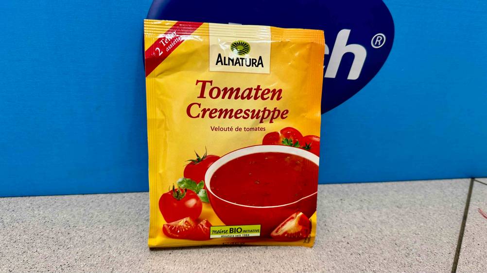 Eine getestete Tütensuppe steht vor einem blauen Karton auf dem Boden.