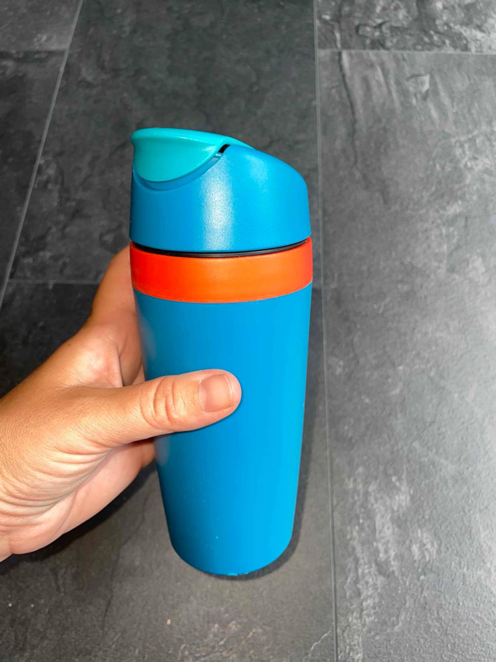 Im Test: Verschlossener Coffee-to-go Becher der Marke Tupperware in der Hand