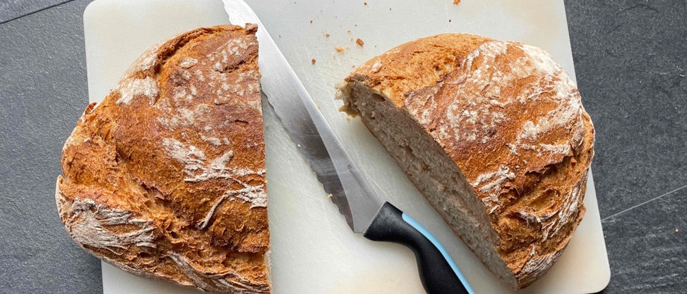 Brotmesser im Test: Ein Brotmesser zwischen zwei Brothälften. 