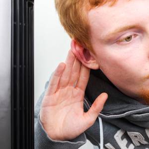 Redakteur hält sein Ohr an einen Turmventilator