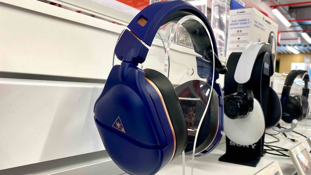 PS4-Bluetooth-Headset-Test: Lilafarbenes Modell befindet sich neben einem weißen Over-Ear-Kopfhörer auf einem Ausstellungsregal.