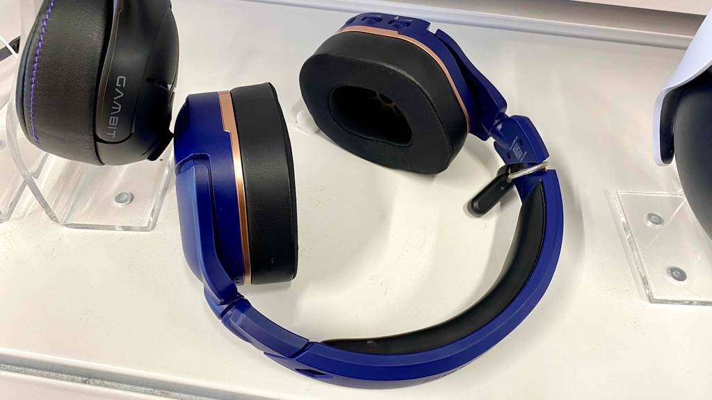 PS4-Bluetooth-Headset im Test: Lilafarbenes Modell liegt zwischen anderen ausgestellten Over-Ear-Kopfhörern auf einem weißen Regal.