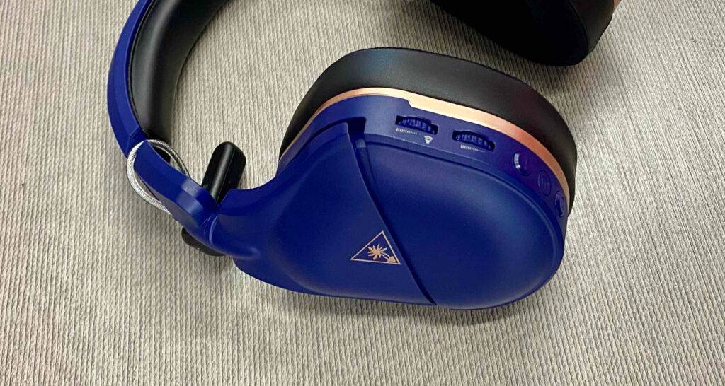 PS4-Bluetooth-Headset-Test: Seitenansicht auf eine Ohrmuschel inklusive Lautstärkenregler eines blauen Bluetooth-Over-Ear-Kopfhörers.