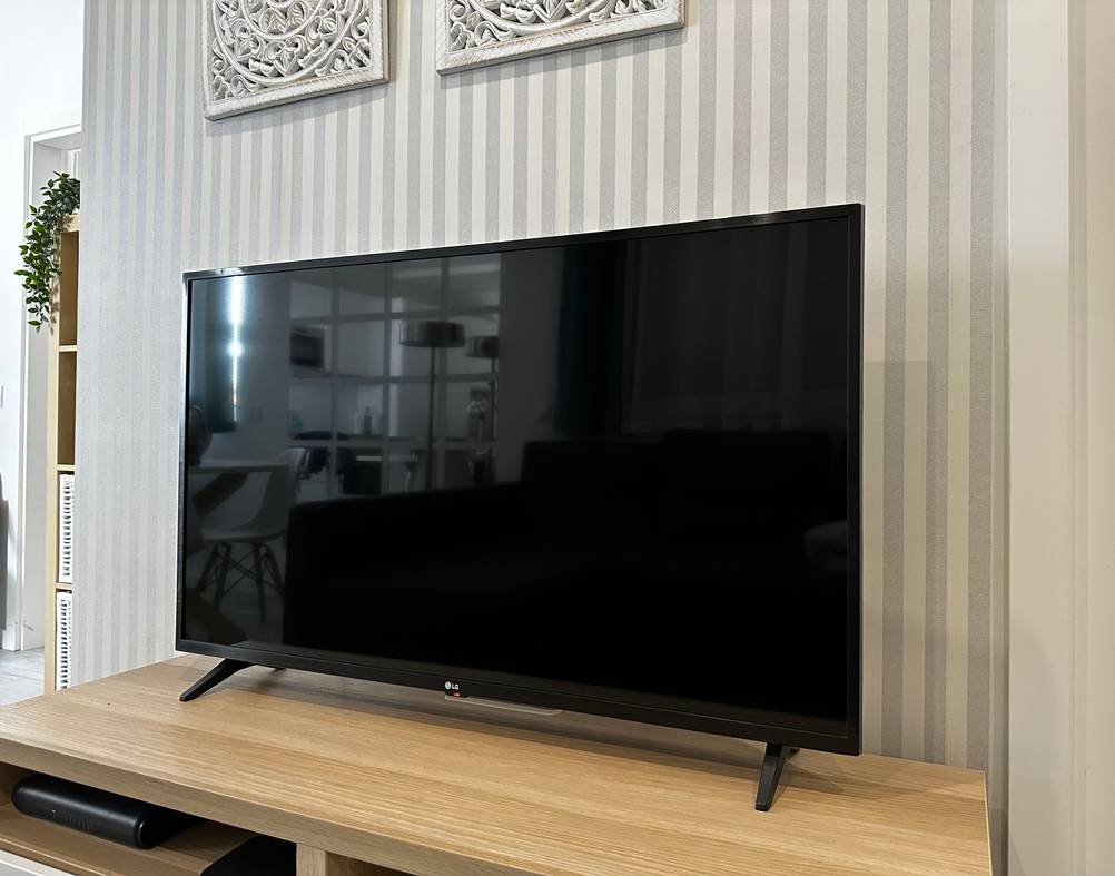 Ein schwarzer Flachbildschirm-Fernseher von LG im Wohnzimmer.