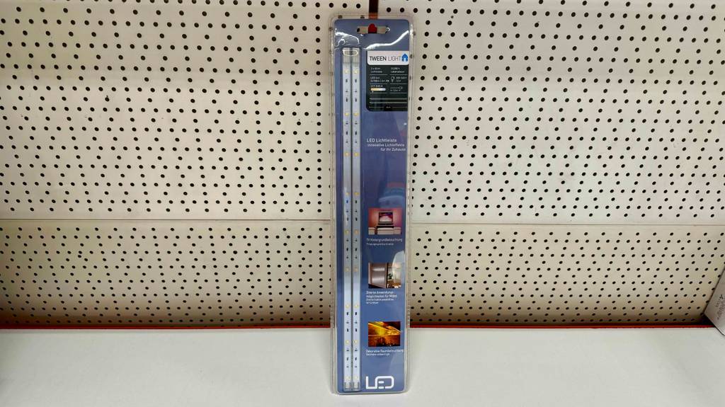 Im Test: eine TV-Hintergrundbeleuchtung, verschweißt in der Originalverpackung, steht vor einer weißen Lochwand.