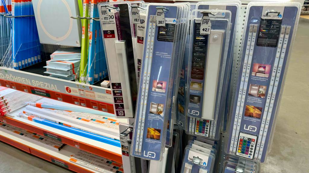 TV-Hintergrundbeleuchtungen im Test, in ihren Originalverpackungen, hängen an einem Verkaufsstand.