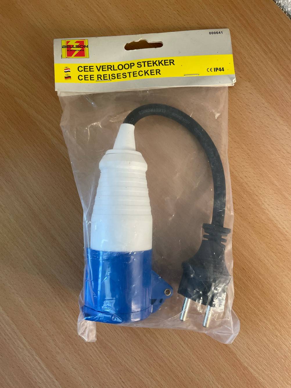Ein verpacktes Typ 2-Ladekabel liegt zum testen auf einer Holzfläche.
