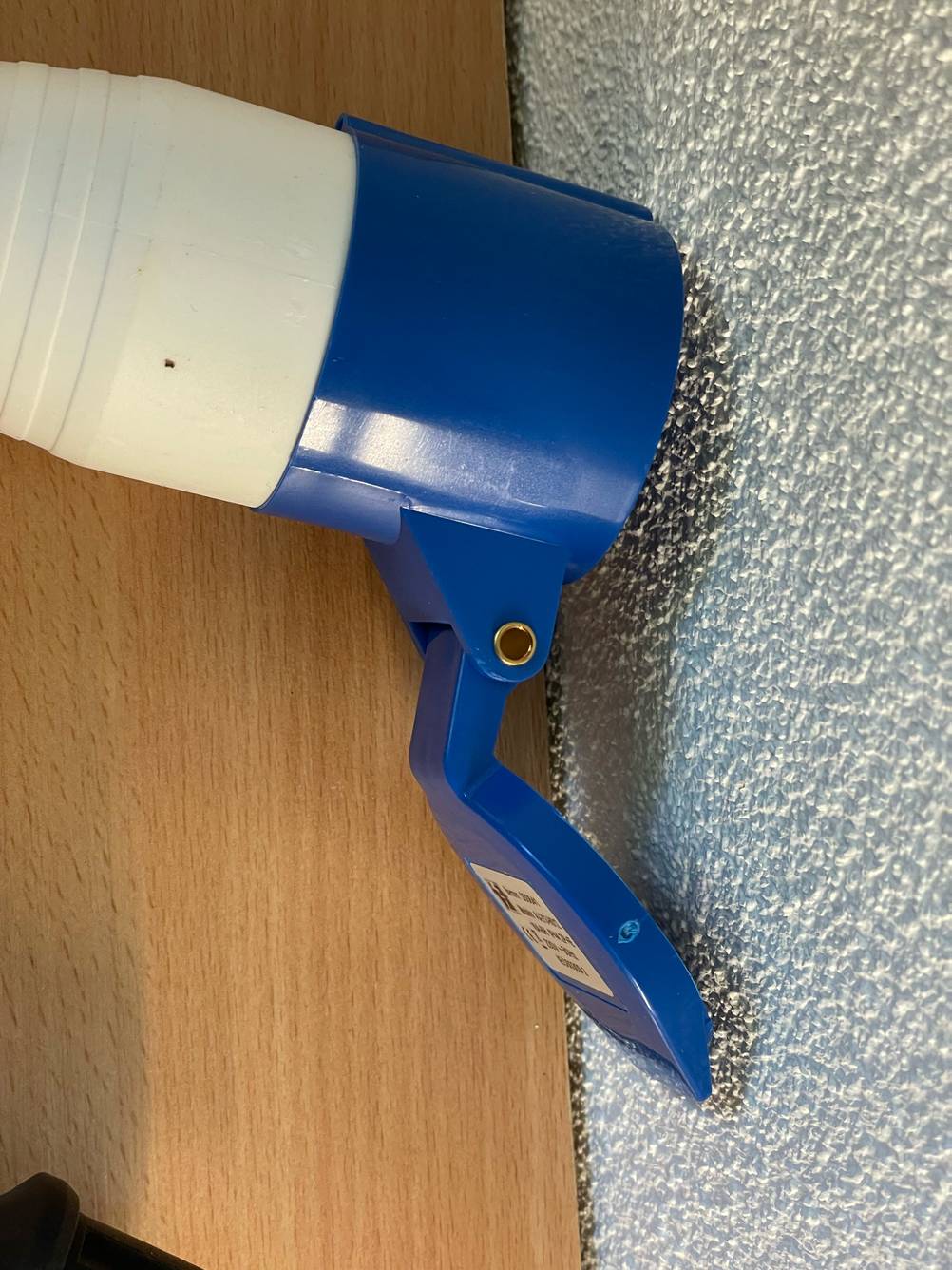 Im Test: Ein Typ 2-Ladekabel liegt mit aufgeklapptem Deckel vor einer weißen Wand.