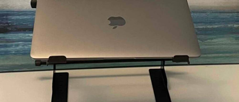 Im Test: Ein Laptop steht auf einem Laptop-Ständer vor einer bemalten Wand.