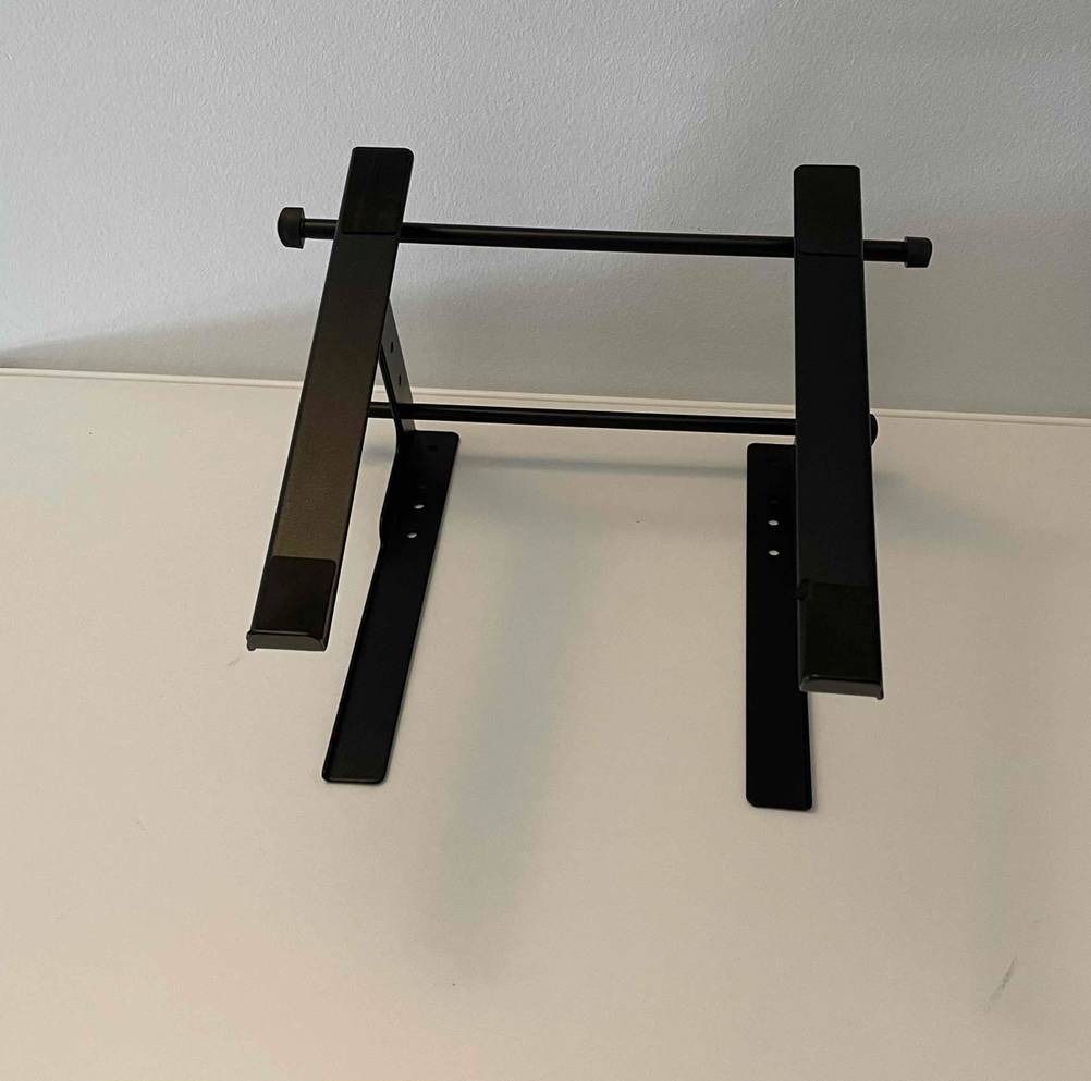 Sicht auf die Unterseite mit Standfüßen eines getesteten Laptop-Ständers, der vor einer weißen Wand liegt.