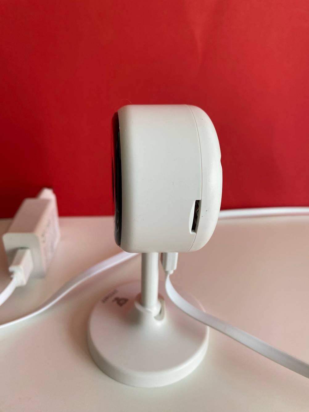 Im Test: Seitenansicht einer Überwachungskamera vor einer roten Wand.