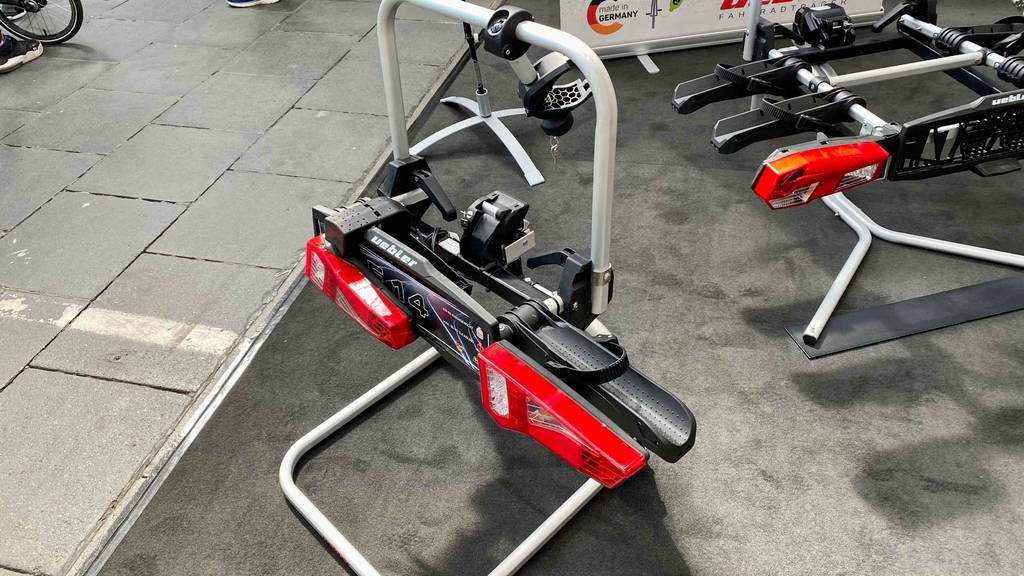 Ein Uebler Fahrradträger steht zum Testen mit anderen auf einem grauen Boden.