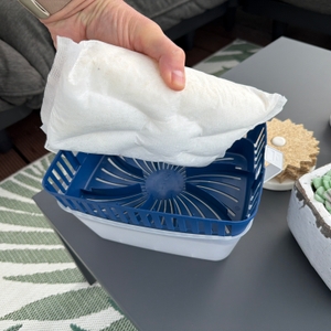 Eine Hand holt eine Packung Uhu-GmbH-&-Co.-KG-Dehumidifier nach der Benutzung aus einem Luftentfeuchter