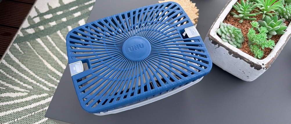 Der Uhu-Luftentfeuchter Original steht auf einem grauen Tisch