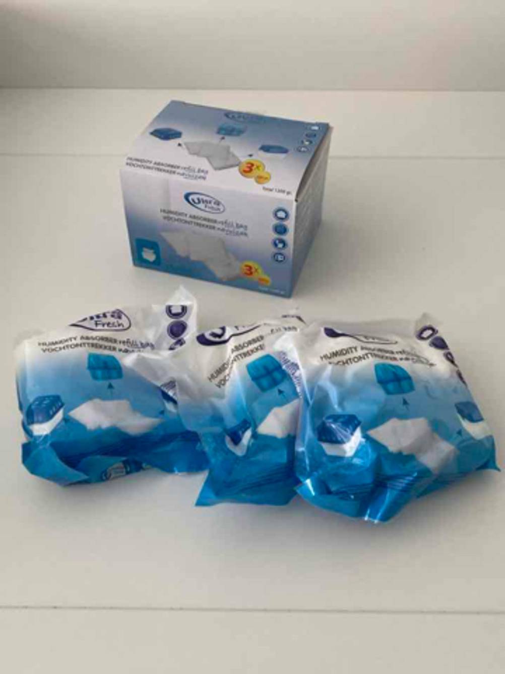 Silica-Gel im Test: Drei weiß-blaue Kunststoffbeutel liegen vor ihrer Verpackung.
