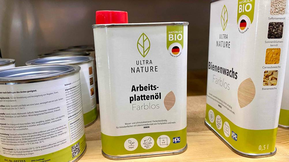 Ein Kanister getestetes Arbeitsplattenöl neben anderen Produkten im Regal.