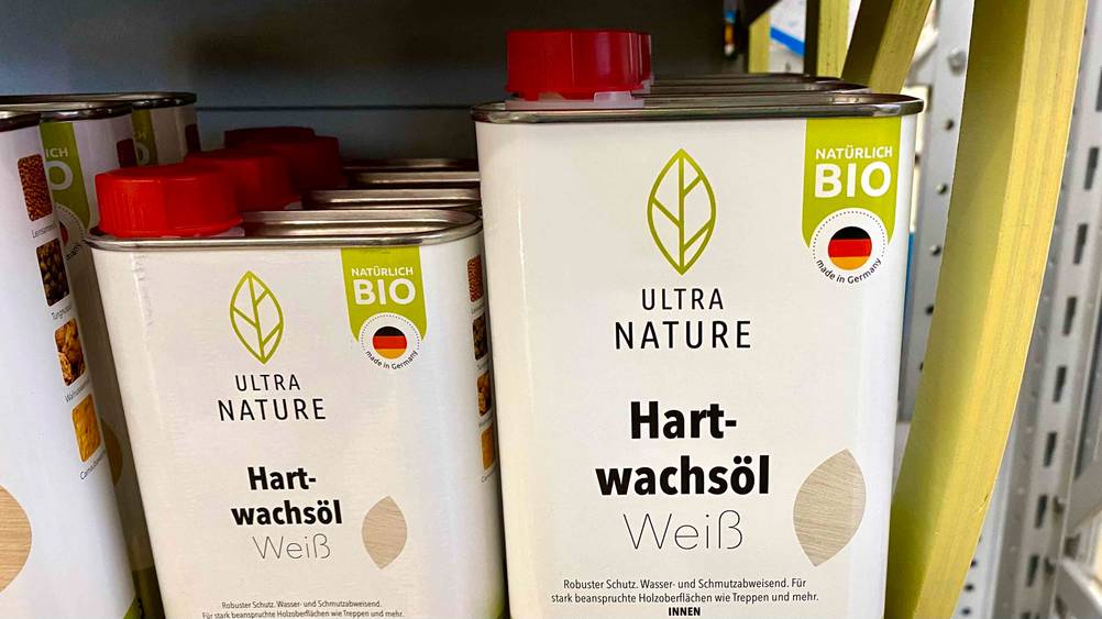 Im Test: Mehrere Dosen Hartwachsöl in verschiedenen Größen von Ultra Nature stehen neben- und hintereinander in einem Regal.