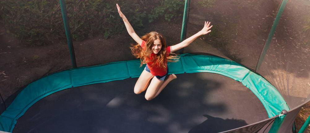 Ultrasport-Trampolin im Test: Eine junge Frau die in einem großen Trampolin mit Netz springt.