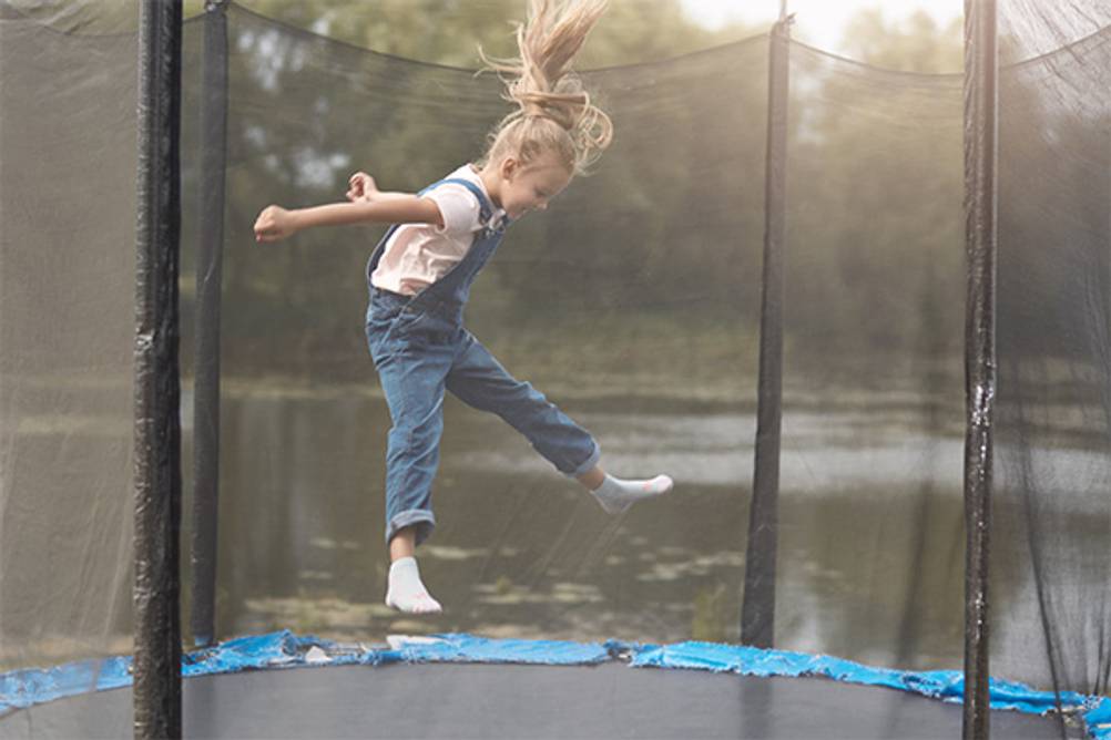 Ultrasport-Trampolin im Test: Ein Mädchen auf Socken, das in einem Trampolin springt.