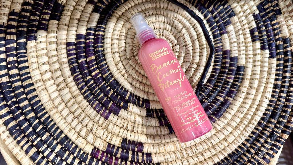 Im Test: Ein Conditioner-Spray in der 250-ml-Sprühflasche liegt auf einer Matte aus Bast. 