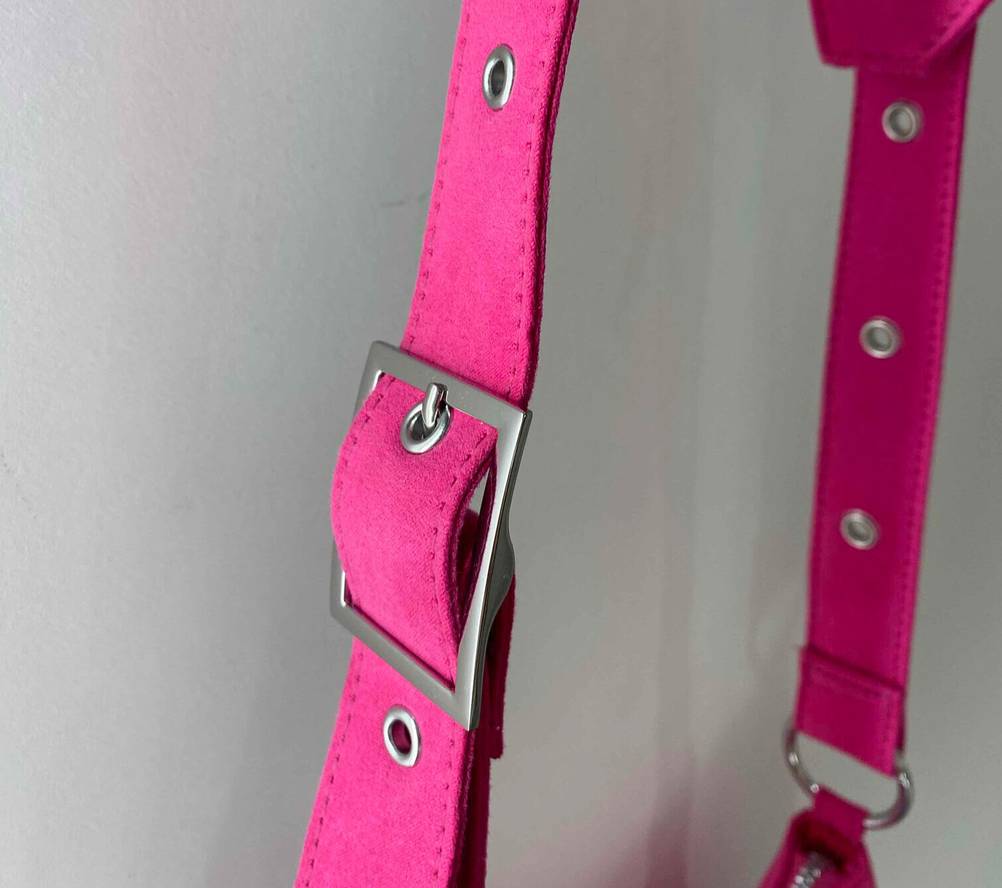 Umhängetasche für Damen getestet: Nahaufnahme der Schnalle am Gurt einer pinkfarbenen Tasche.